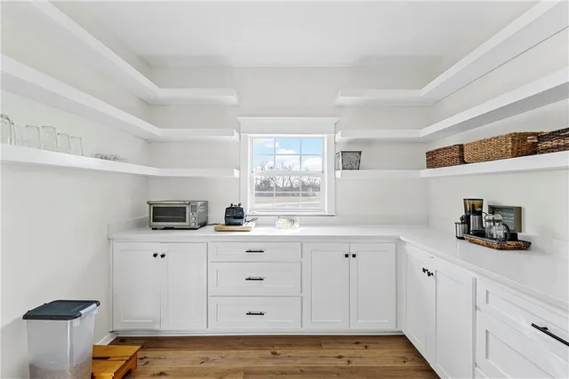 a kitchen with white cabinets and sink