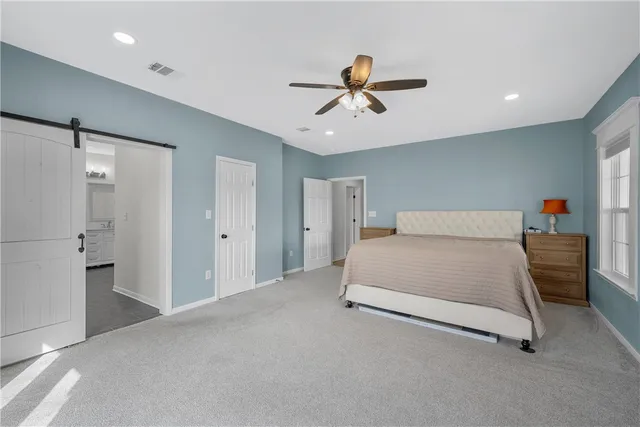 a spacious bedroom with a bed and a chandelier