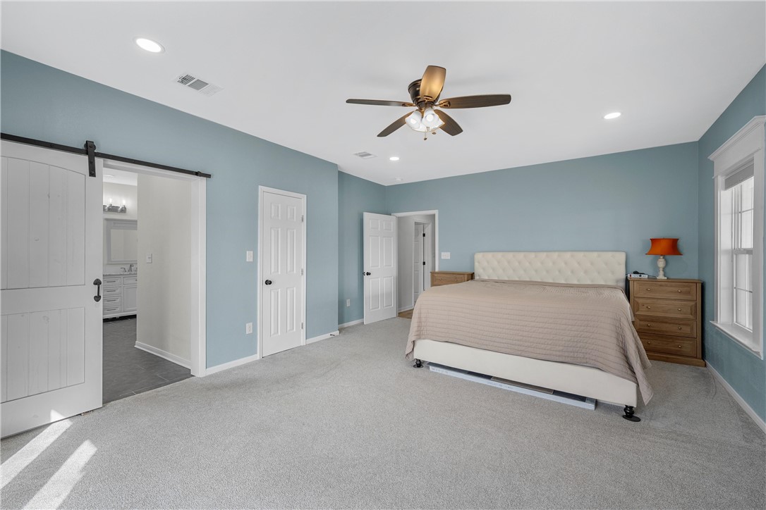 15966 Old China Spring Road China Spring, TX 76633 - Photo 25 of 45 a spacious bedroom with a bed and a chandelier