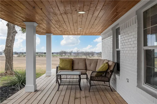 a balcony with couple of chairs and wooden floor
