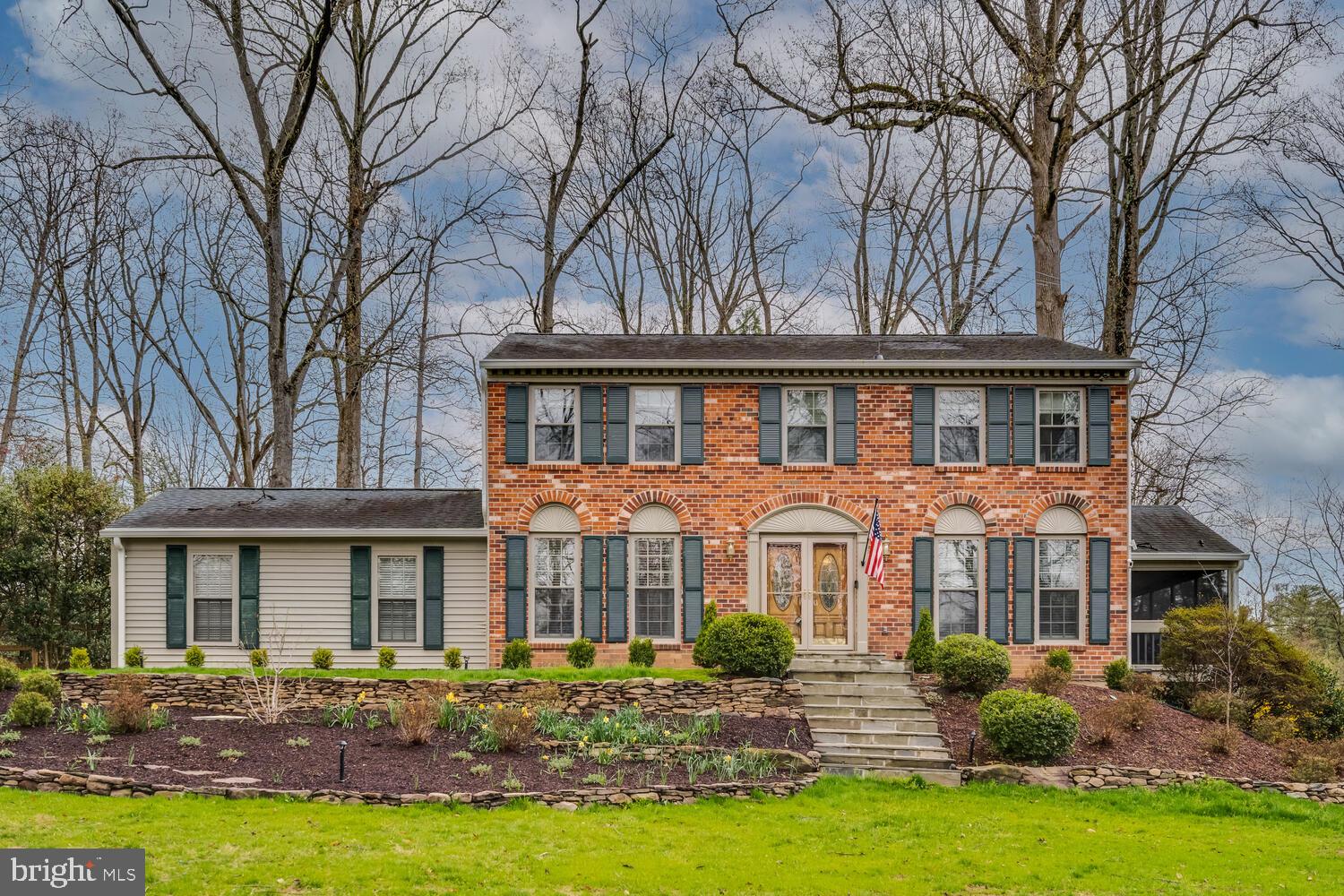 a front view of a house with yard and green space