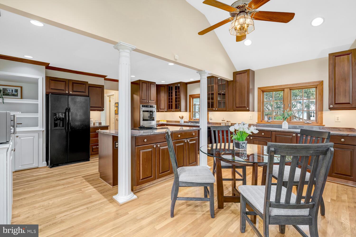 723 Forest Park Road Great Falls, VA 22066 - Photo 21 of 71 a kitchen with stainless steel appliances kitchen island granite countertop a refrigerator a stove top oven and a dining table with wooden floor