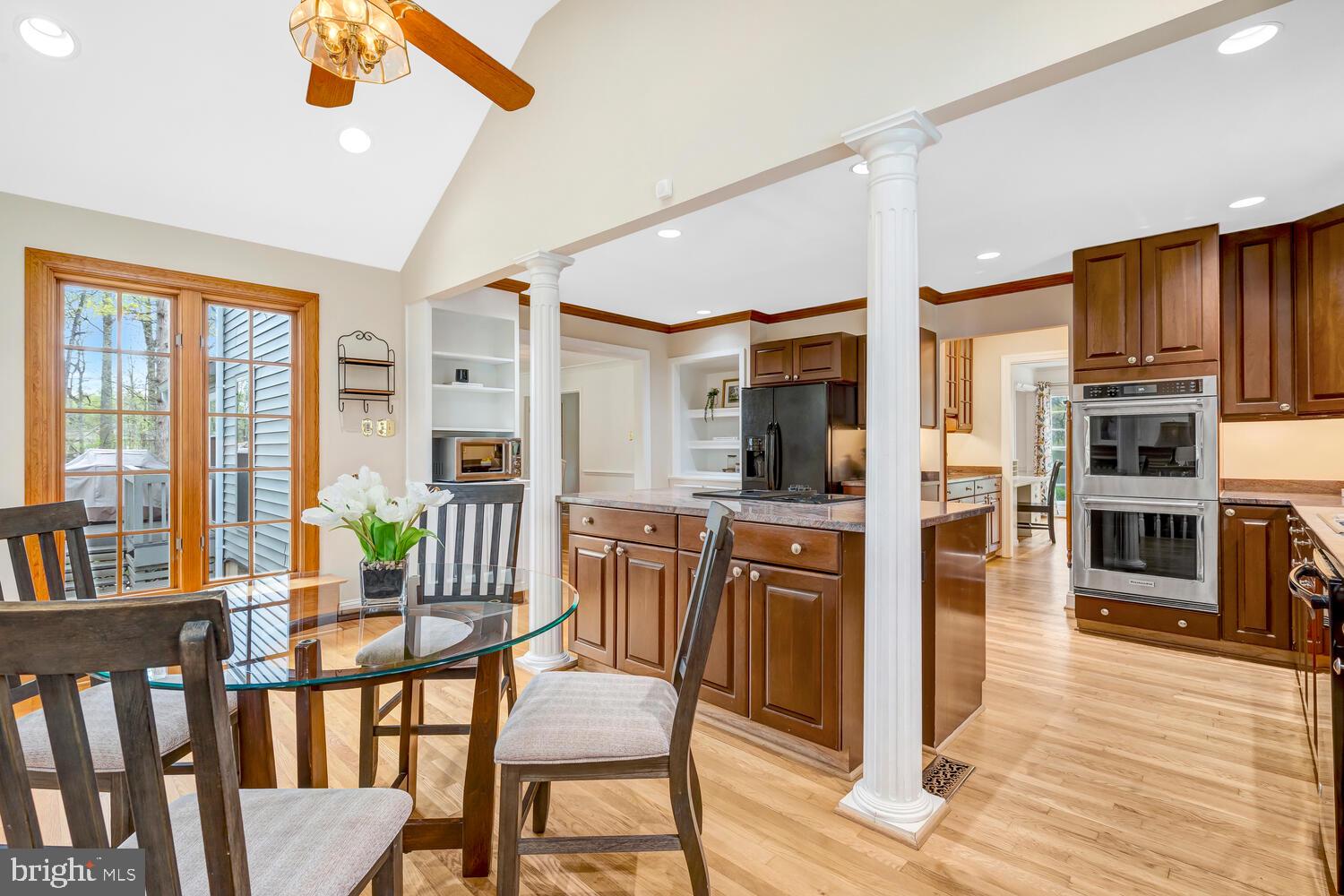 723 Forest Park Road Great Falls, VA 22066 - Photo 27 of 71 a kitchen with stainless steel appliances wooden floor dining table and chairs