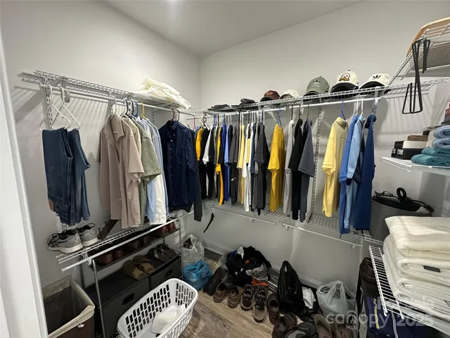 a view of walk in closet with clothes and shoes