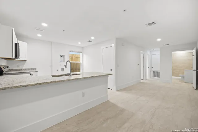 a view of kitchen with stainless steel appliances cabinets