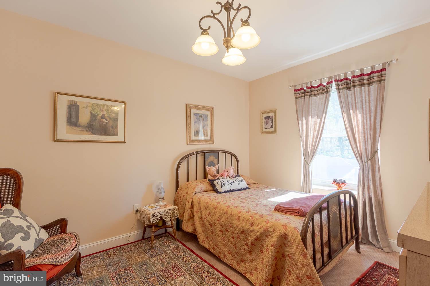 321 Mount Nittany Road Lemont, PA 16851 - Photo 20 of 43 a bedroom with a bed and a chandelier