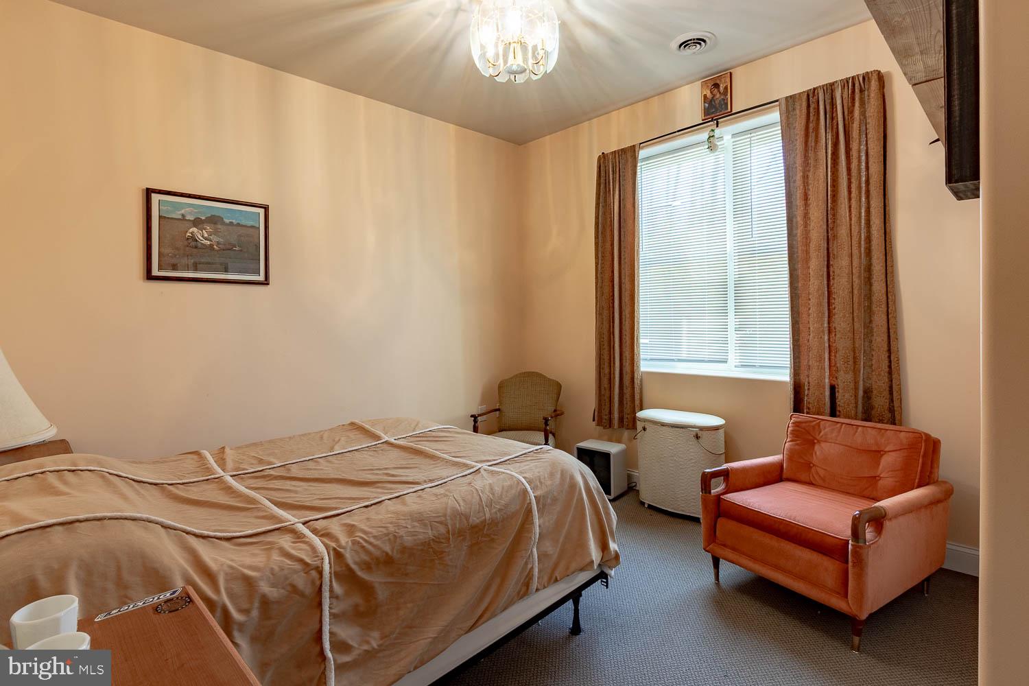 321 Mount Nittany Road Lemont, PA 16851 - Photo 37 of 43 a bedroom with two beds and a chandelier