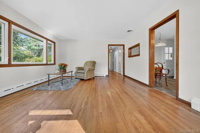 a view of a livingroom with wooden floor and furniture