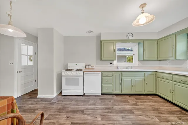a kitchen with a sink cabinets and wooden floor