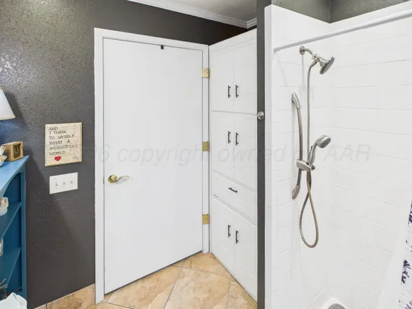 a spacious bedroom with a bed and a flat screen tv