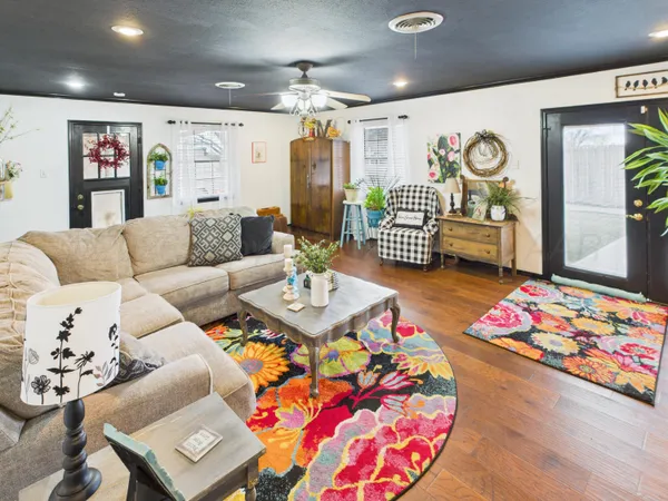 a living room with patio furniture and a chandelier