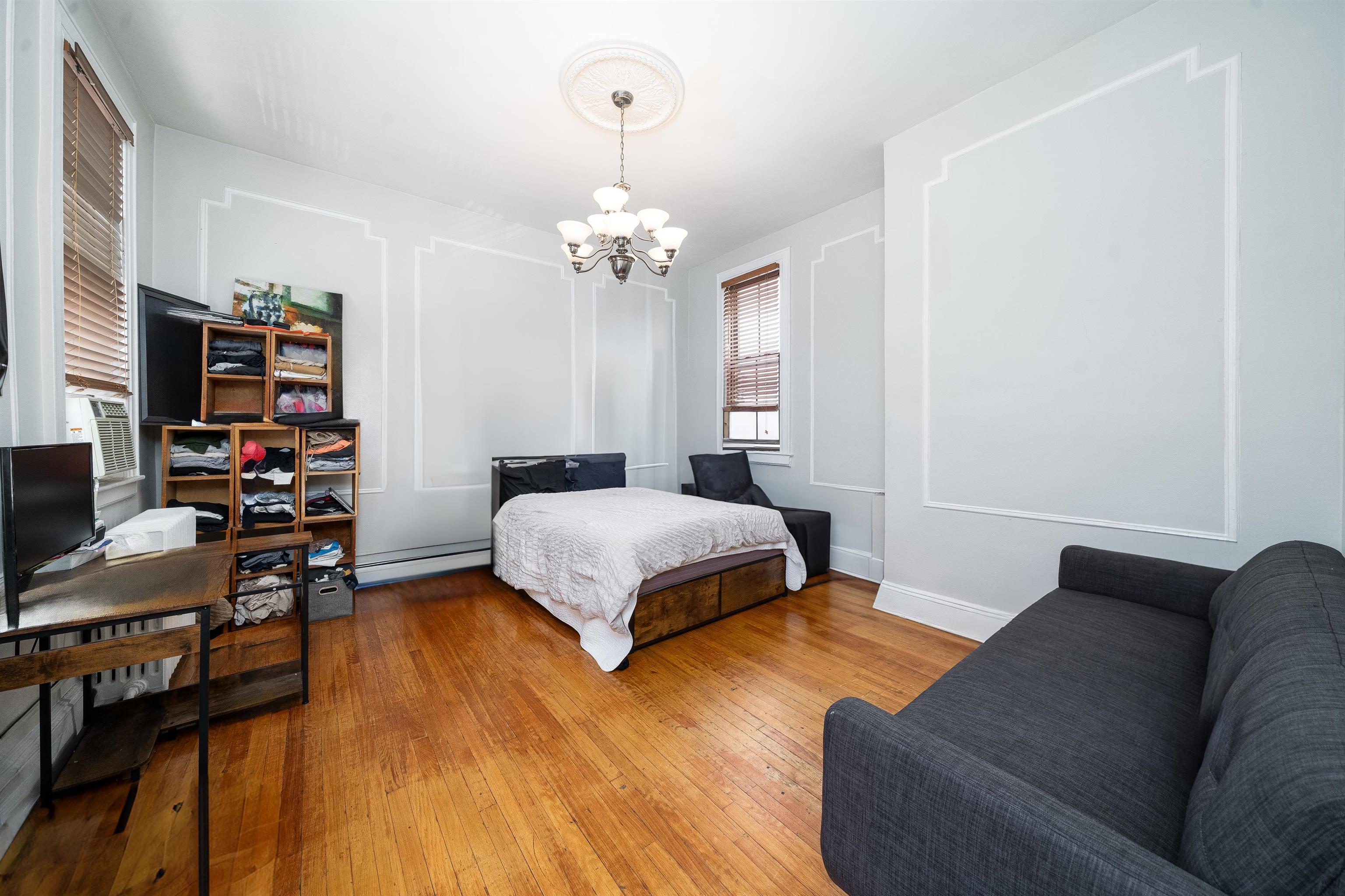 800 Bloomfield Street Hoboken, NJ 07030 - Photo 15 of 38 a bedroom with a bed chandelier and a window