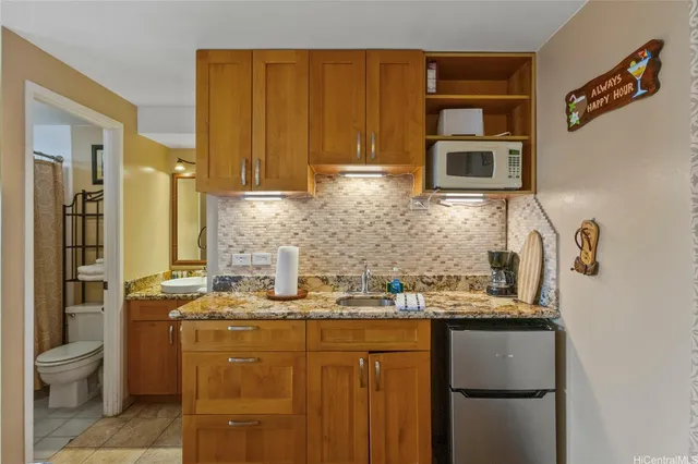 a kitchen with stainless steel appliances kitchen island granite countertop a refrigerator and a stove top oven