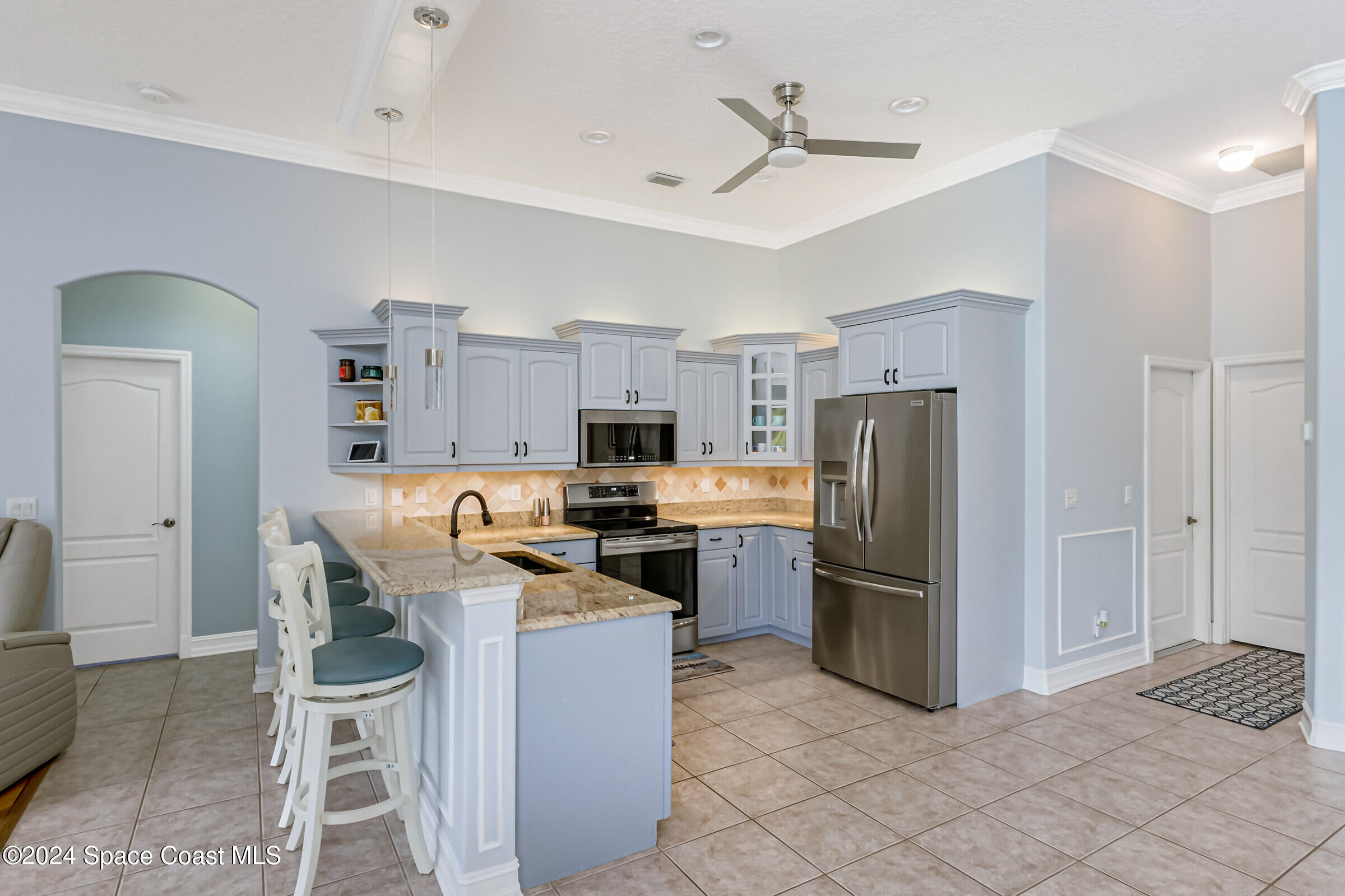 4481 Aberdeen Circle Rockledge, FL 32955 - Photo 12 of 50 a kitchen with refrigerator cabinets and outdoor space