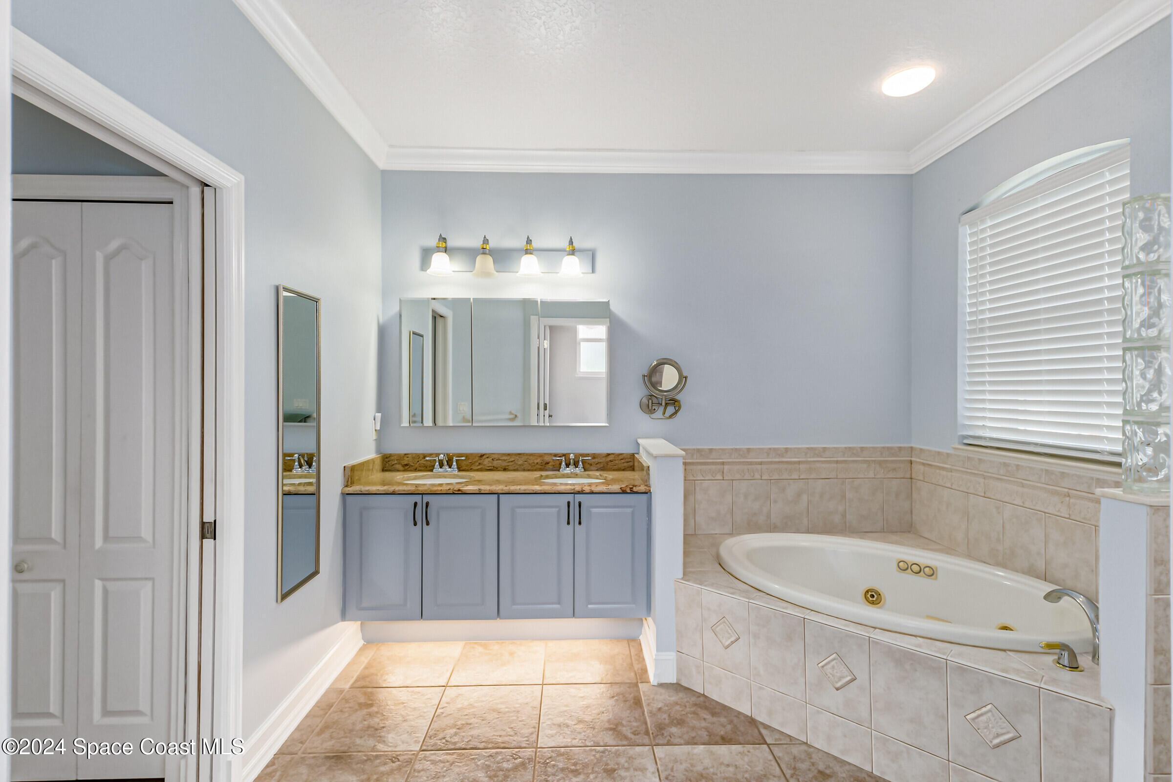 4481 Aberdeen Circle Rockledge, FL 32955 - Photo 21 of 50 a bathroom with a granite countertop bathtub a sink and a mirror
