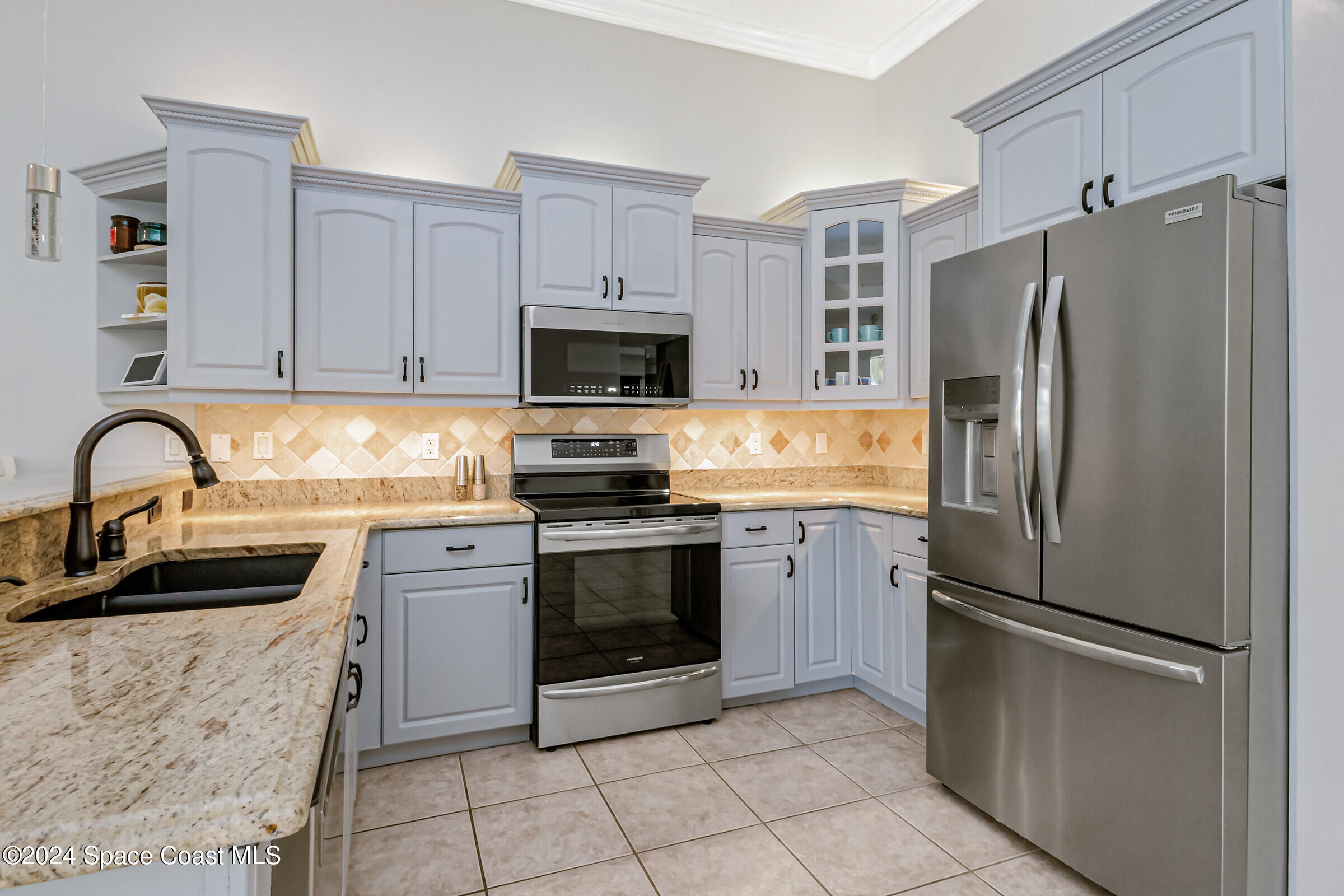 4481 Aberdeen Circle Rockledge, FL 32955 - Photo 9 of 50 a kitchen with stainless steel appliances granite countertop a refrigerator sink and stove