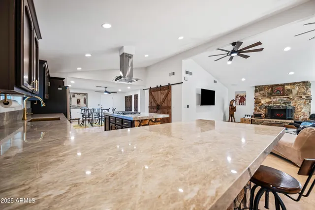 a view of a roof deck with table and chairs a barbeque with wooden floor and fence