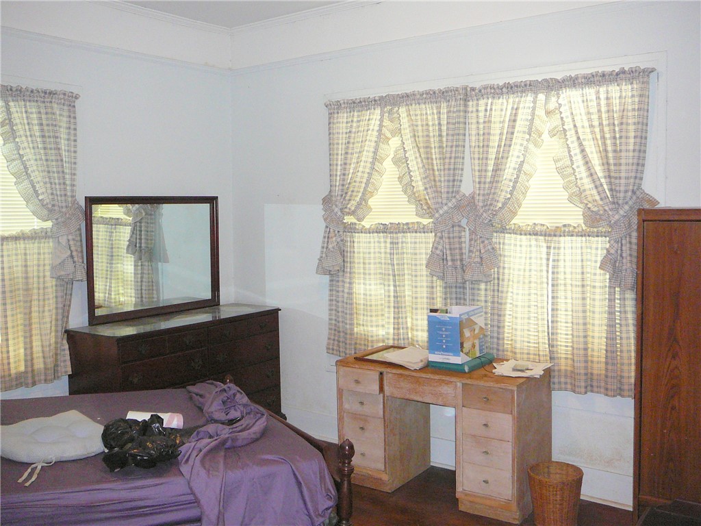 306 B Street Anderson, SC 29625 - Photo 7 of 8 This cozy bedroom features bright windows, a dark wood floor, and classic window coverings.
