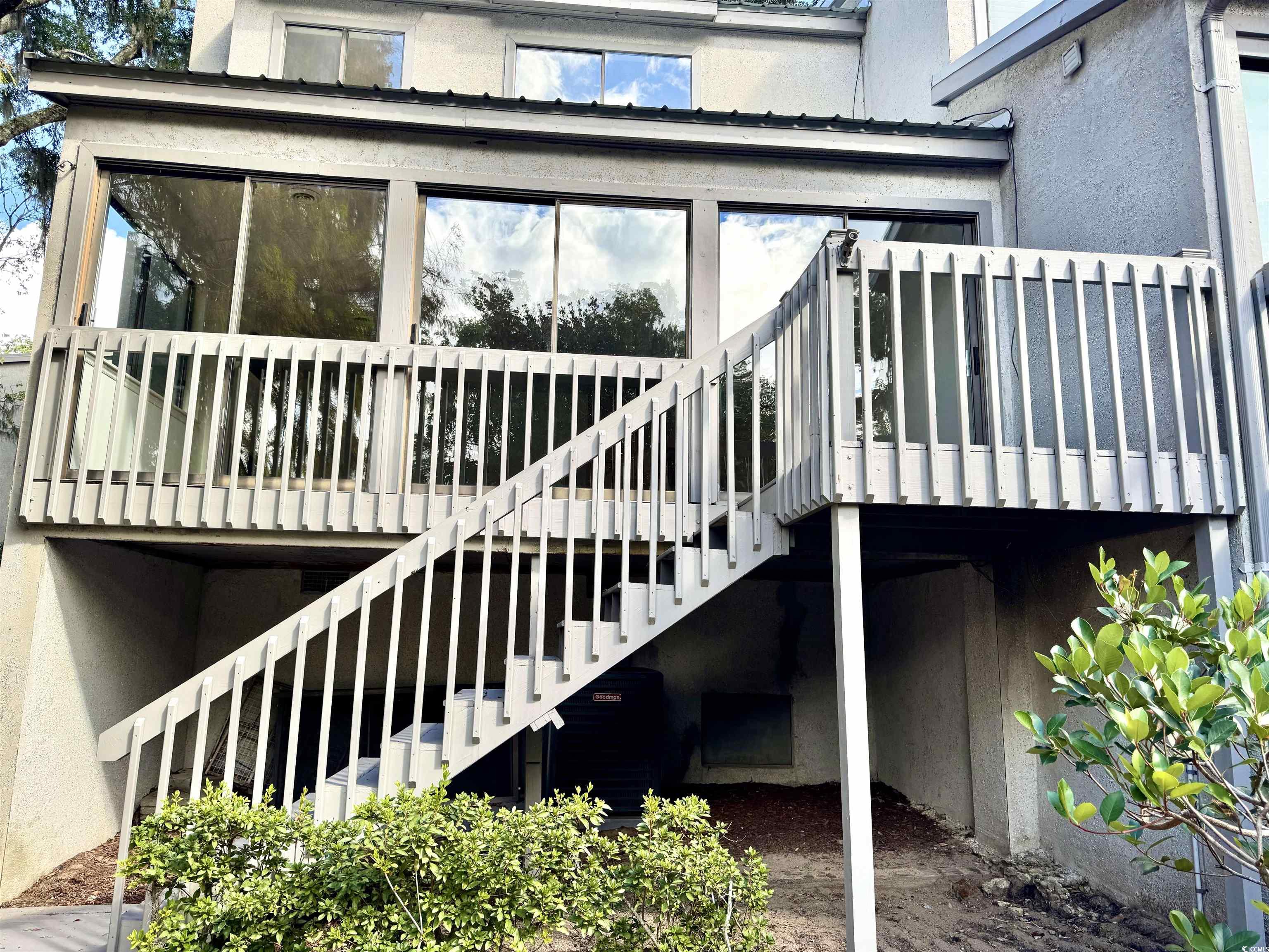 31 Battery White Court, Unit 1005 Georgetown, SC 29440 - Photo 14 of 34 Rear view of property featuring stucco siding, a deck, and stairway