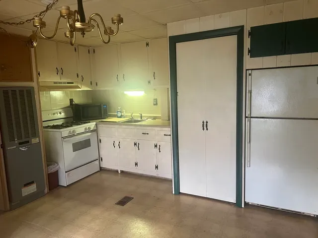 a kitchen with white cabinets and white appliances