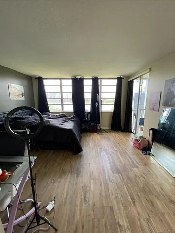 a bedroom with a bed a couch and large windows