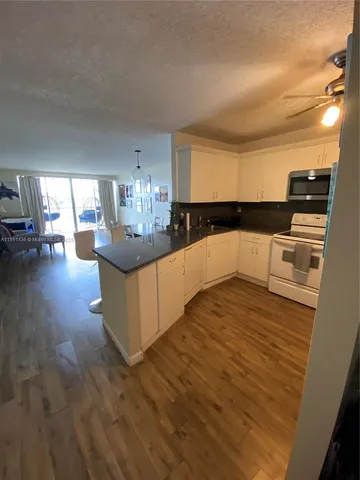 a view of a living room and kitchen with furniture