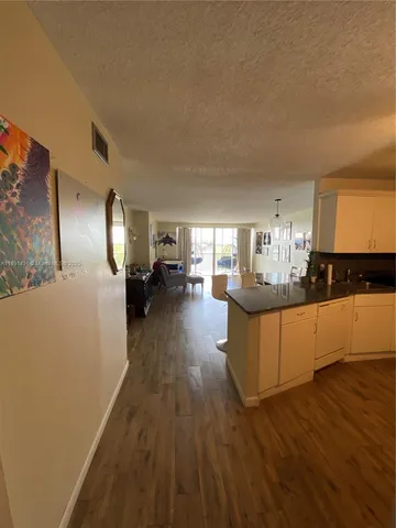 a kitchen with counter top space and wooden floor