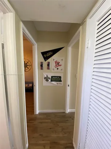 a view of a hallway with wooden floor and closet