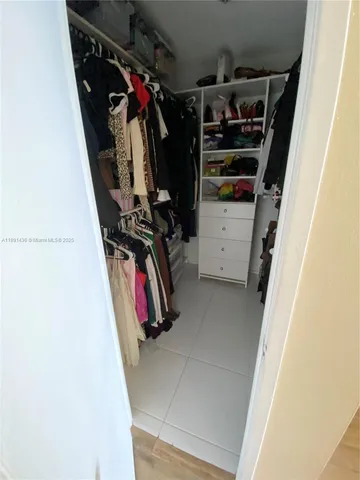 a view of walk in closet with clothes and shoes