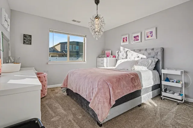 a bedroom with a bed and a chandelier