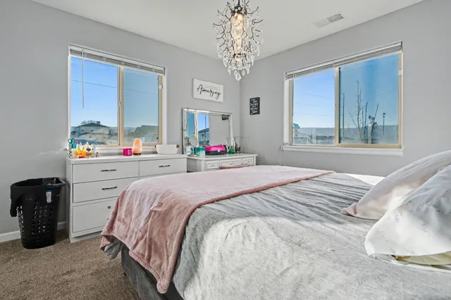 a bedroom with a bed and dresser with mirror