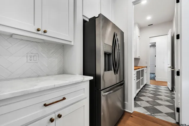 a kitchen with stainless steel appliances a refrigerator and cabinets