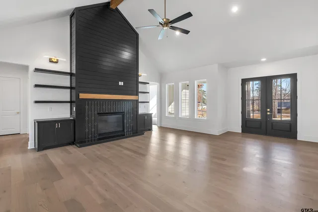 a view of an empty room with a fireplace and a window