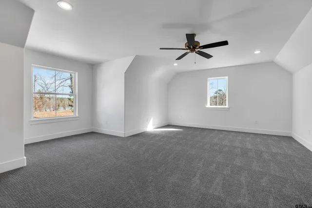 a view of a big room with windows and chandelier fan