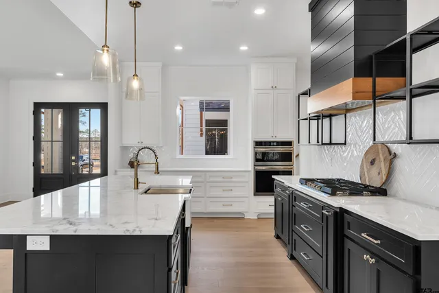 a kitchen with granite countertop kitchen island stainless steel appliances a stove sink microwave and cabinets