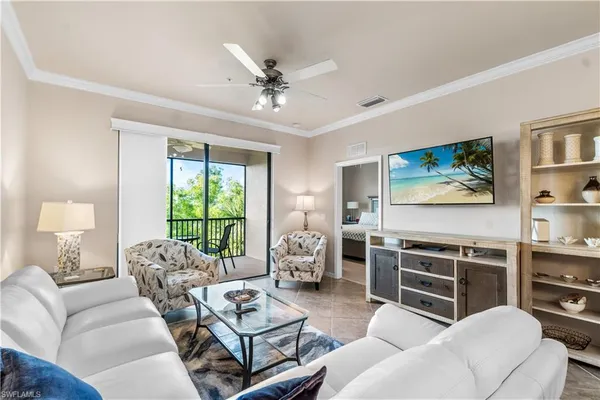 a living room with furniture a chandelier and a flat screen tv