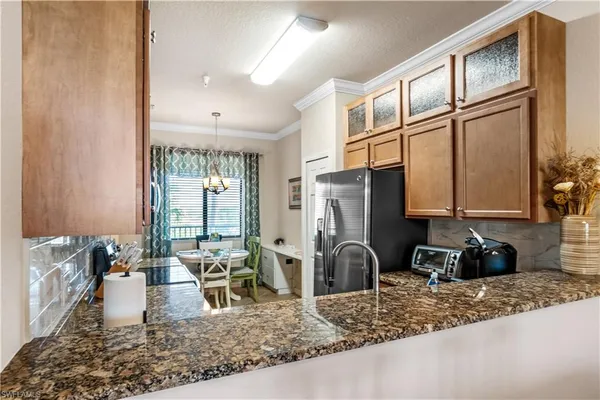 a kitchen with refrigerator a stove and a sink with wooden floor