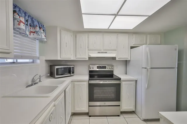 a kitchen with a sink a refrigerator and cabinets