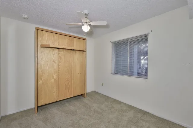 an empty room with chandelier fan