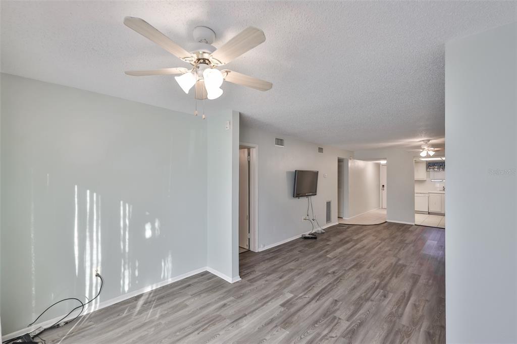 801 83rd Avenue North, Unit 118 St. Petersburg, FL 33702 - Photo 4 of 37 a view of an empty room with wooden floor and a ceiling fan