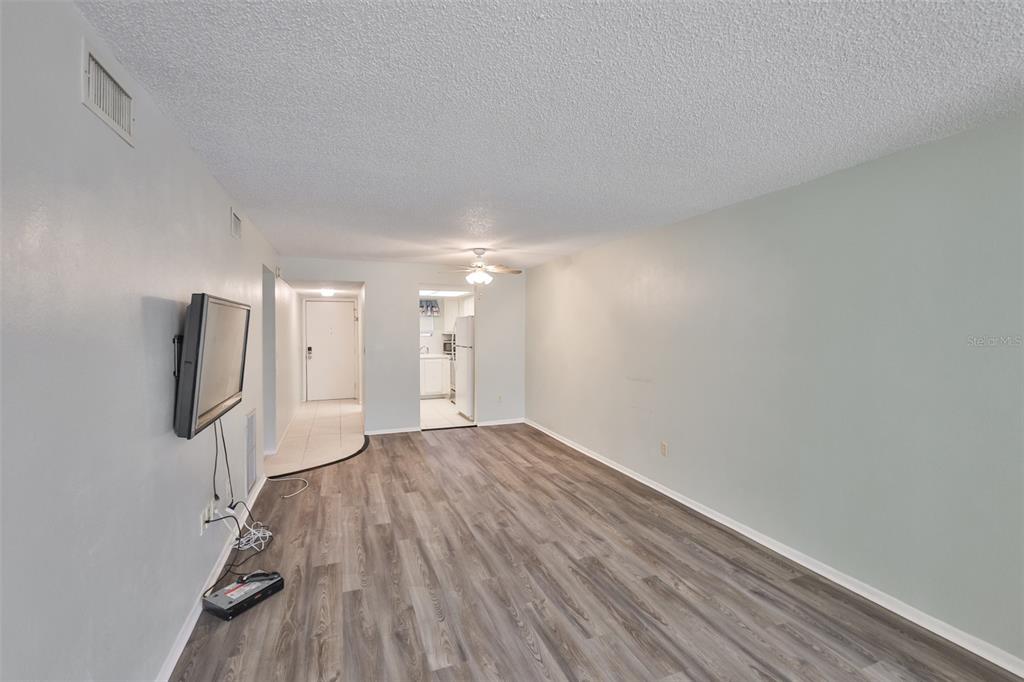 801 83rd Avenue North, Unit 118 St. Petersburg, FL 33702 - Photo 6 of 37 a view of empty room with wooden floor and fan