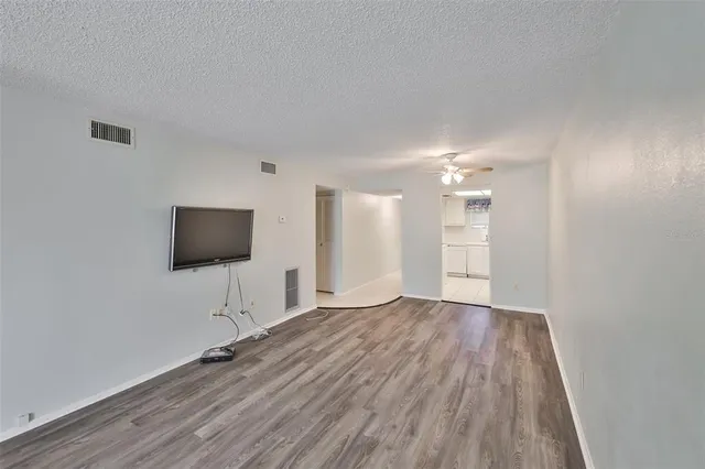 a view of a livingroom with wooden floor and a flat screen tv