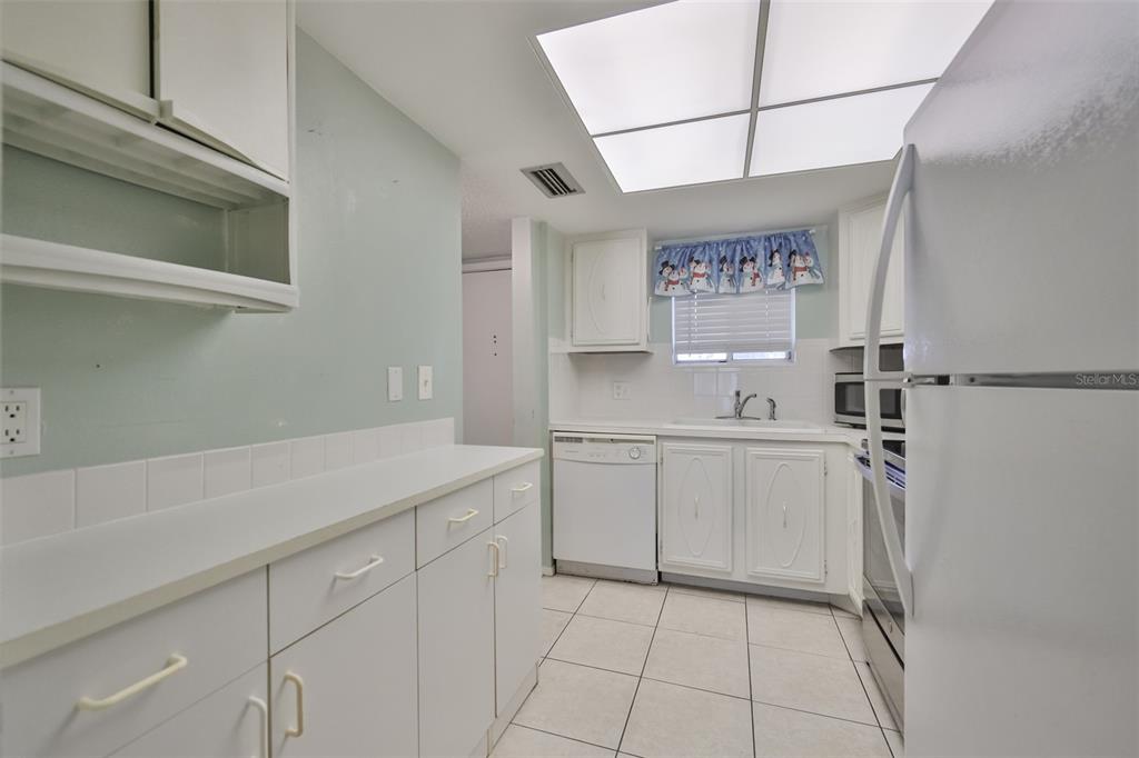 801 83rd Avenue North, Unit 118 St. Petersburg, FL 33702 - Photo 9 of 37 a kitchen with a sink cabinets and window