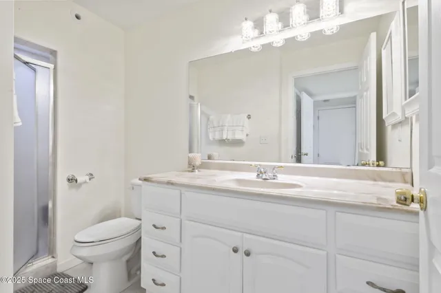a bathroom with a granite countertop sink a toilet and a mirror