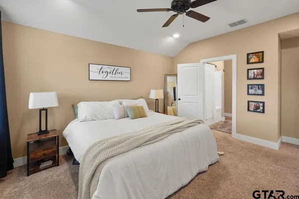 a spacious bedroom with a bed and a lamp