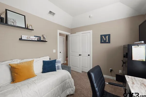 a bedroom with a bed and a chair in it