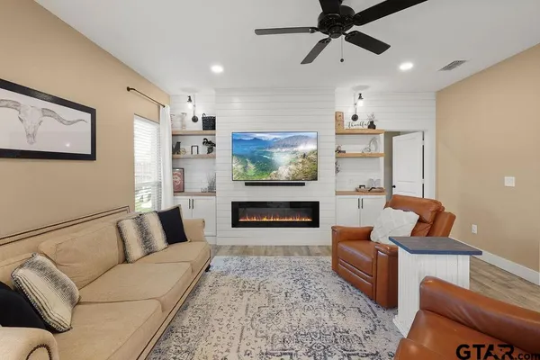 a living room with furniture flat screen tv and a fireplace