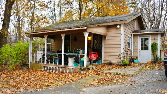 a view of a house with a tree and wooden fence