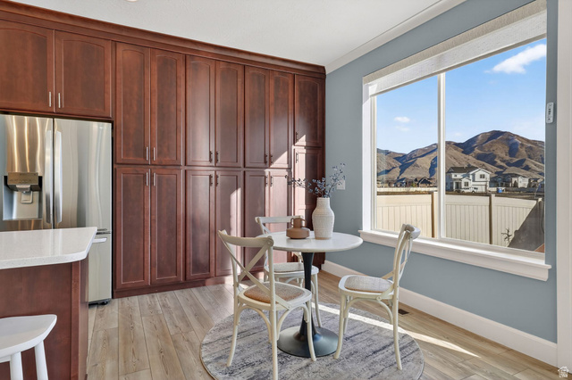1222 West 190th Street North Mapleton, UT 84664 - Photo 14 of 46 Built-in cabinetry in a rich wood tone, stainless steel refrigerator, and light wood-finish flooring