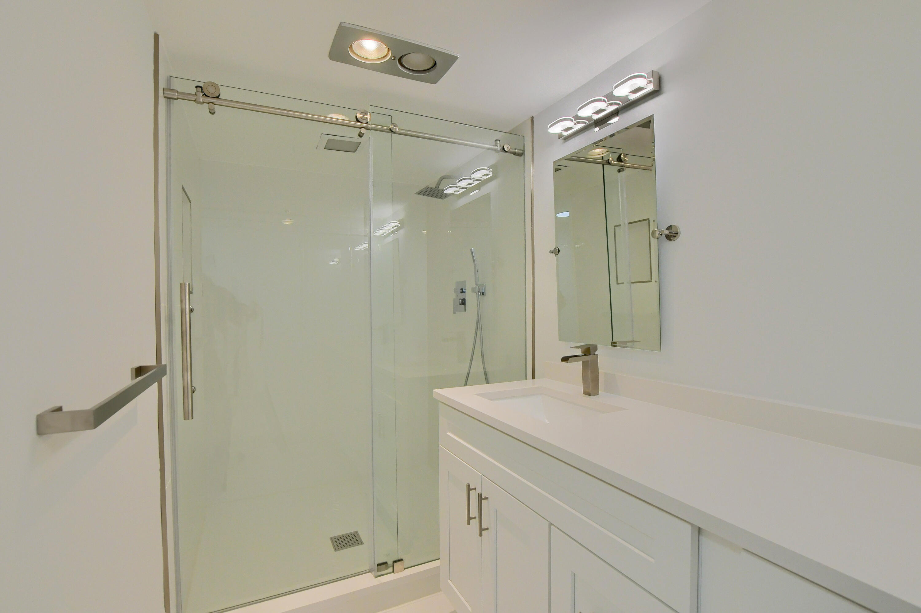 9170 Southwest 14th Street, Unit 4405 Boca Raton, FL 33428 - Photo 17 of 48 a bathroom with a shower sink vanity and mirror